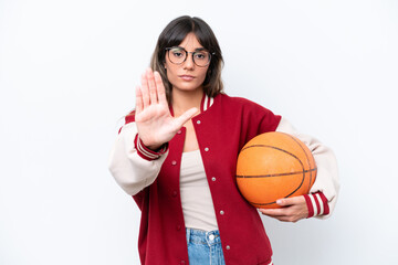 Young caucasian woman playing basketball isolated on white background making stop gesture