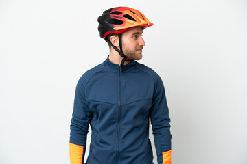 Young cyclist man isolated on white background looking to the side