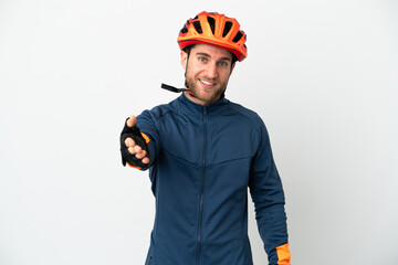 Young cyclist man isolated on white background shaking hands for closing a good deal
