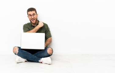 Young man sitting on the floor celebrating a victory