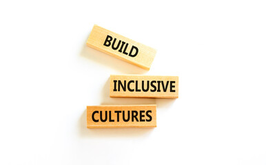 Build inclusive cultures symbol. Concept words Build inclusive cultures on wooden blocks. Beautiful white table white background. Business build inclusive cultures concept. Copy space.