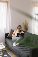 Lifestyle portrait of woman reading a book at home