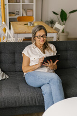 Adult woman having video call at home using tablet