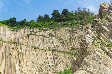 Fototapeta premium natural landscape with a sheer cliff folded columnar basalt on the seashore
