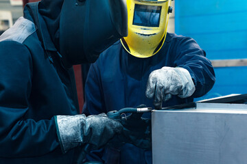 experienced worker welder instructs a young one before starting welding