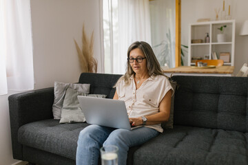 Adult woman using laptop at home