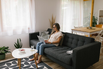 Adult woman using laptop at home