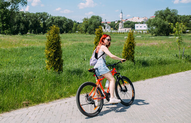 Young woman in the city rides bike and leads an active lifestyle doing sports