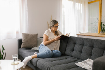 Woman reading a book at home