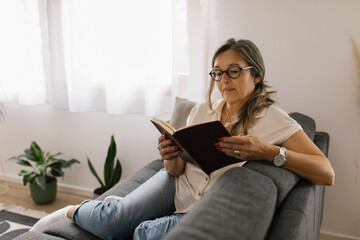 Woman reading a book at home