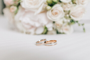 Wedding rings on a table with white flowers and a jewelry box. Wedding day details.