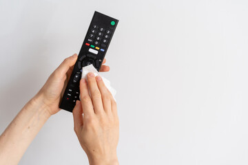 person cleaning tv remote with wet wipe, closeup