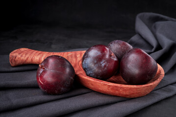 Obraz premium Fresh purple plum on black background