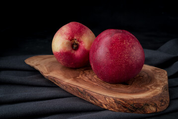 Nectarines with slices on wooden background