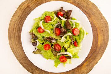 Healthy salad with chicken on a plate, lettuce, and organic vegetables, top view