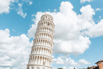 Amazing beautiful white tilted tower against the blue cloudy sky in Pisa. Travel and vacations in...
