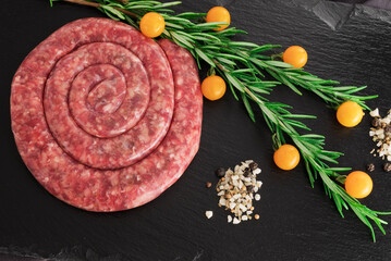 Spiral pork sausage on black board