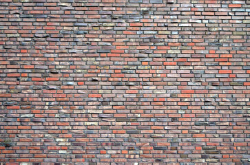 Colorful wide brick wall background with small red and grey bricks. Texture of a brick wall for wallpapers, slides, screensavers and other types of backgrounds