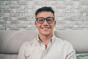 Portrait of one young attractive man looking at the camera smiling and having fun sitting on the...