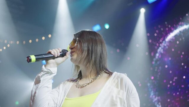 duet of young female singer and male rapper on stage, concert of popular pop and hip-hop band