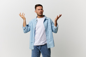 Fototapeta premium Confused thoughtful tanned handsome man in casual basic t-shirt raise hand up make difficult decision posing isolated on white studio background. Copy space Banner. Lifestyle People emotions concept