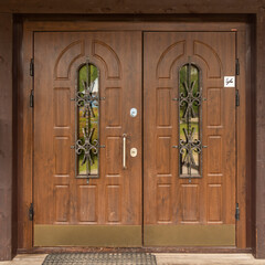 Obraz premium massive two-leaf wooden entrance door from the street.