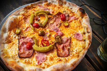 Pepperoni pizza with bacon and cheese on wooden table,