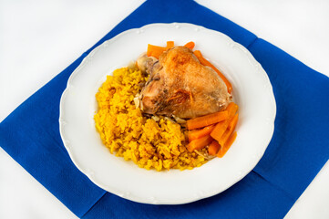 Baked chicken breast, roasted carrot and stewed turmeric and saffron rice, blue towel.