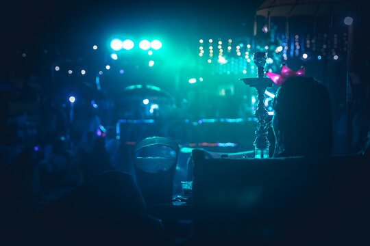 Shisha bar lounge in smoke with spotlights in the night dark blue colors