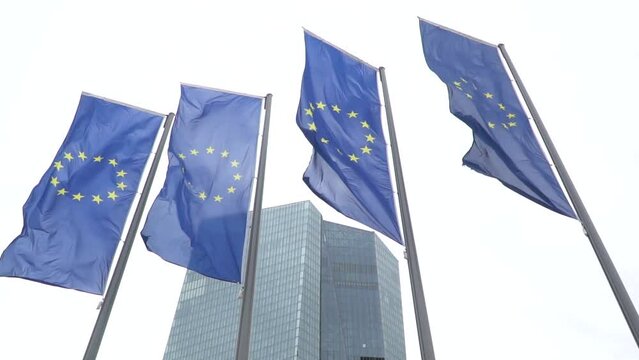 View of European Union EU flags in front of the new headquarters building of the European Central Bank located in Ostend, Frankfurt. Germany.