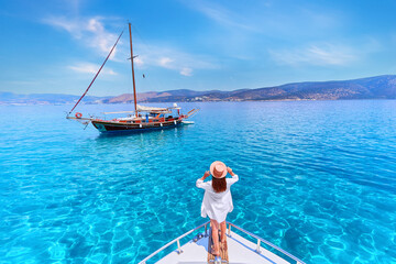 Traveler girl enjoys relaxing vacation on a luxury white private boat in the turquoise sea