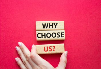 Why choose us symbol. Concept words Why choose us on wooden blocks. Beautiful red background. Businessman hand. Business and Why choose us concept. Copy space.