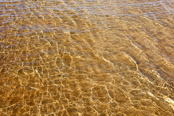 Sea Water and Sand Structure Golden fine sand on the shoreline, creating abstract pattern during the tide