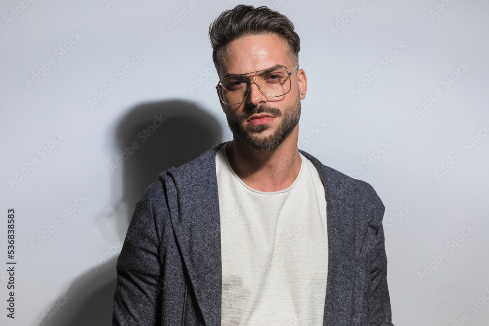 Poster handsome bearded guy with glasses wearing hoodie and posing