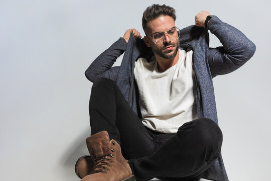 Confident Stylish Man Pulling Hoodie And Looking Away