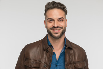 enthusiastic young man wearing brown leather jacket and smiling
