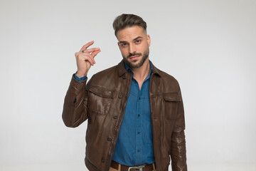 sexy man in casual outfit holding arm in the air and snapping fingers