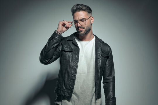 Fashion Model Arranging His Glasses And Looking At The Camera