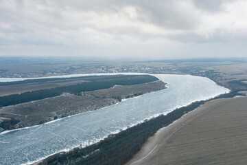 Aerial view of a winding frozen river in winter, heavy frost, beautiful winter landscape