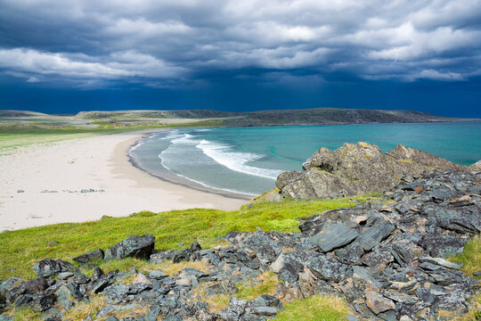 Stormy clouds over beautiful sandy beach in Sandfjordneset Nature Reserve at Varanger national scenic route, Norway