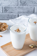 Kefir, buttermilk or yogurt with granola. Yogurt in glass on light background. Probiotic cold...