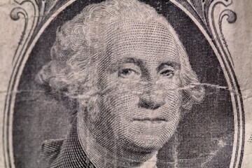 Macro view of George Washington on worn out dirty US one dollar bill.