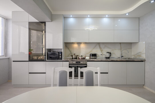 Interior of modern trendy white kitchen, front view