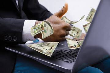Iraqi dinar notes coming out of laptop with Business man giving thumbs up, Financial concept. Make money on the Internet, working with a laptop - obrazy, fototapety, plakaty