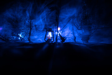 Spooky dark landscape showing silhouettes of trees in the swamp on misty night.