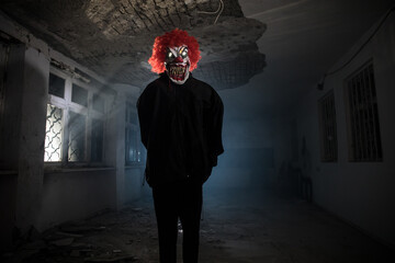 closeup of a scary evil clown with red hair and white eyes, staring at the observer, with a red...
