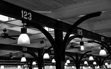 Black and white photo of the lights and rafters at French Market in New Orleans.