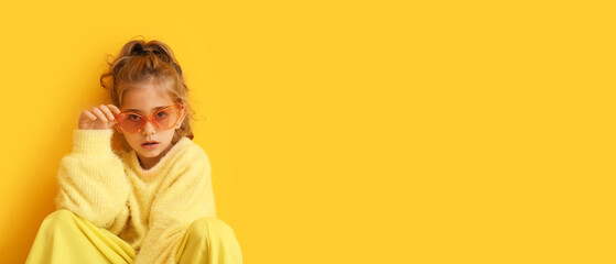 Cute fashionable girl on yellow background with space for text