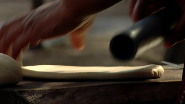 Woman Rolling Dough while Making Traditional Bread Outdoors in Argentina. Close Up.