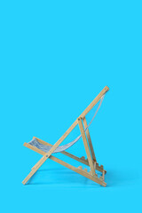 Beach deck chair on light blue background